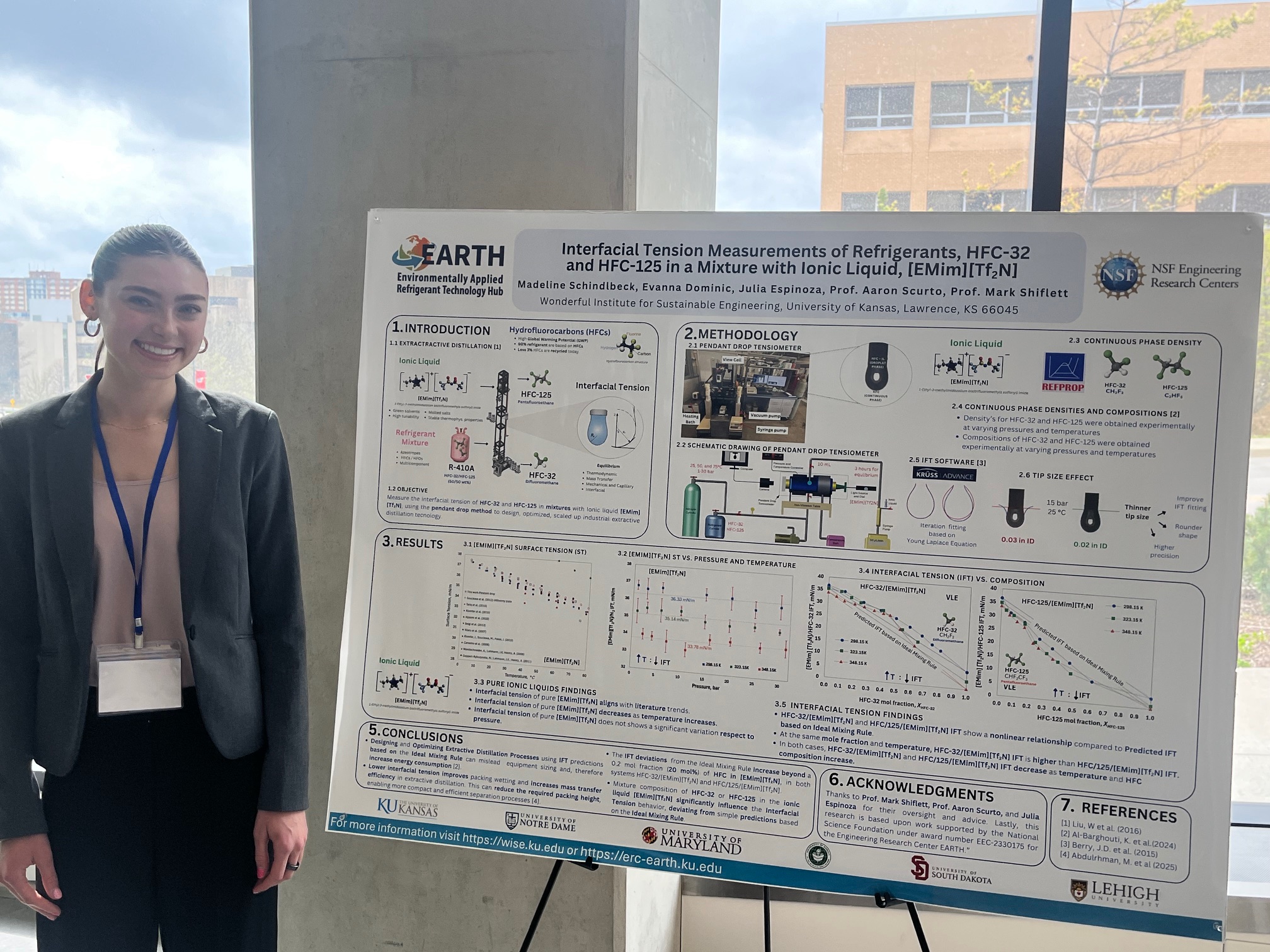 person stands next to research poster